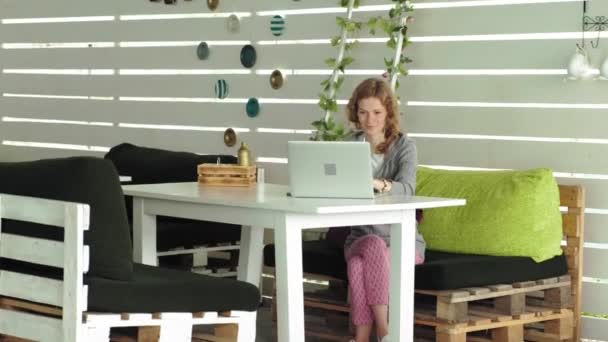 Jeune femme d'affaires avec ordinateur portable dans un café extérieur — Video
