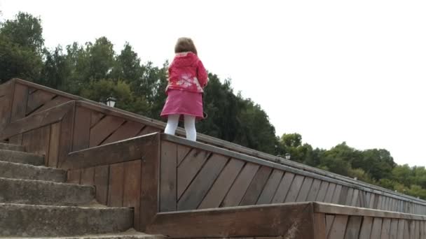 Krásná holčička se dívá dalekohledem na pláži — Stock video