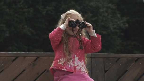 Όμορφο κοριτσάκι που αναζητούν μέσα από κιάλια στην παραλία — Αρχείο Βίντεο
