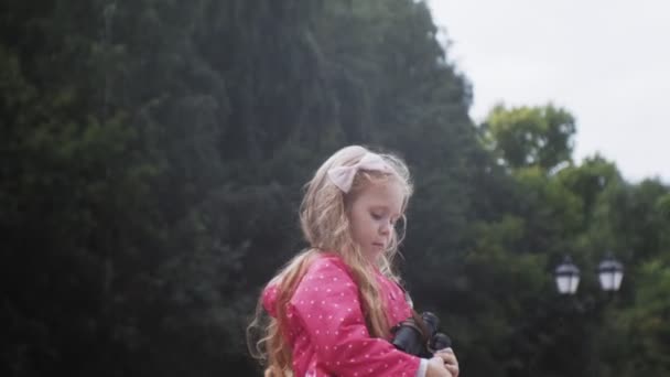 Little beautiful girl looking through binoculars on the beach — Stock Video