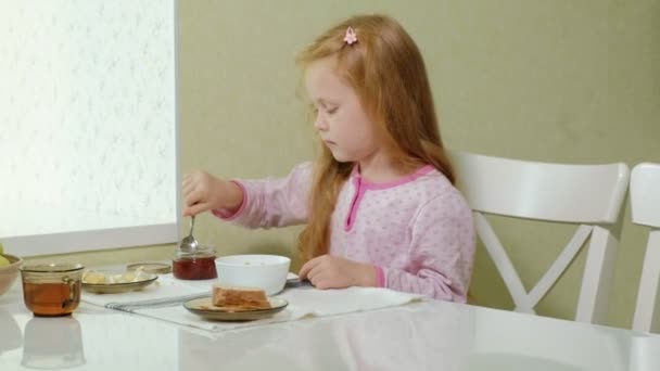 Niña comiendo gachas en la cocina en casa — Vídeos de Stock