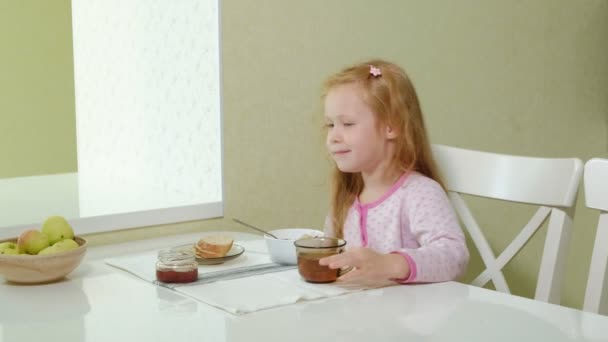 Niña comiendo gachas en la cocina en casa — Vídeos de Stock