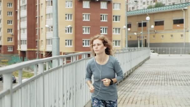 Junge Fitness-Frau bei einem Gymnastiklauf in einem Wohngebiet Super-Zeitlupe — Stockvideo