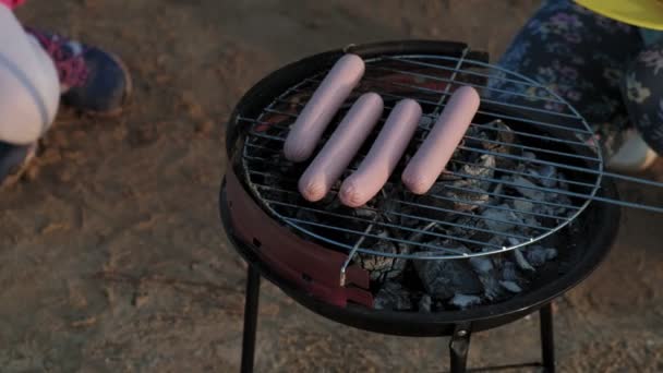 Mãe e filha fritam carne e legumes em um churrasco na praia na praia — Vídeo de Stock