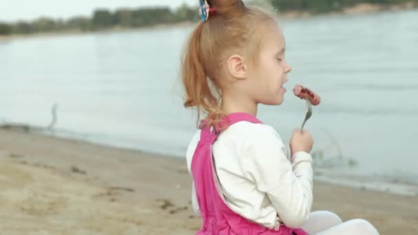 Mãe e filha fritam carne e legumes em um churrasco na praia na praia — Vídeo de Stock