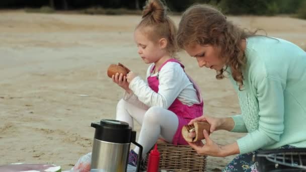 Moeder en dochter bak vlees en groenten op een barbecue op het strand op het strand — Stockvideo