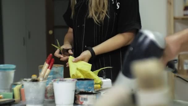 Meesters in de kunststudio verwerken het hout met verf en putty, bereiken het effect van de veroudering — Stockvideo