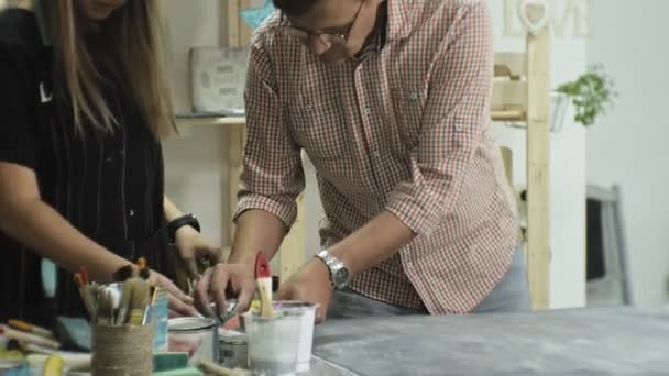 Maestros en el estudio de arte procesan la madera con pintura y masilla, logran el efecto de envejecimiento — Vídeo de stock