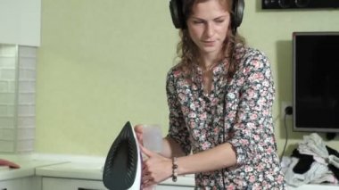 Çamaşırhane evde mutfakta kulaklıklar müzik ve dans dağını Ütü kadın