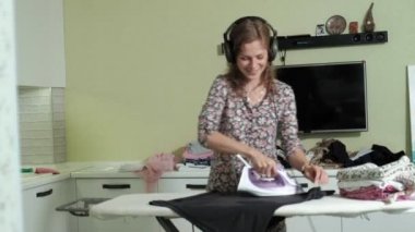 Çamaşırhane evde mutfakta kulaklıklar müzik ve dans dağını Ütü kadın