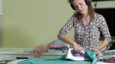 Çamaşırhane evde mutfakta kulaklıklar müzik ve dans dağını Ütü kadın