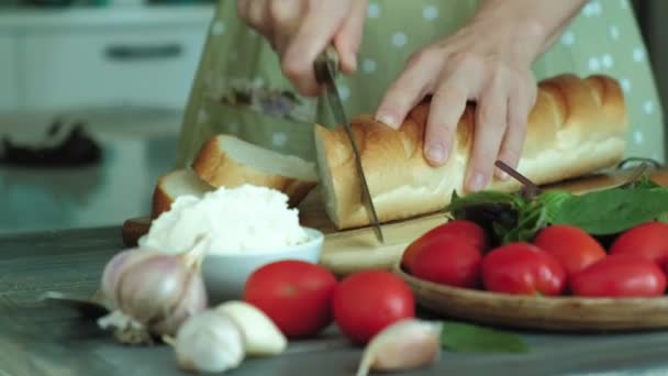 Gros plan d'une main de femme est préparé à partir de fromage à pain et légumes pour une bruschetta italienne . — Video