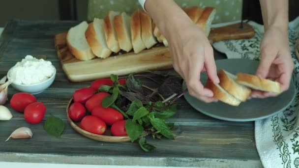 O tiro de close-up de uma mão de mulheres prepara-se de queijo de pão e verduras de uma bruschetta italiana . — Vídeo de Stock