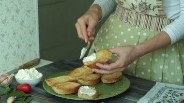 Bir kadının el yakın çekim shot ekmek peynir ve sebze bir İtalyan bruschetta için hazırlanır.