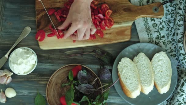 El primer plano de la mano femenina es preparado del queso de pan y hortalizas para la bruschetta italiana . — Vídeo de stock