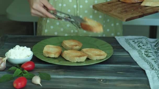 O tiro de close-up de uma mão de mulheres prepara-se de queijo de pão e verduras de uma bruschetta italiana . — Vídeo de Stock