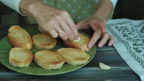 Zbliżenie dłoni womans przygotowuje się z chleba, sera i warzyw dla włoskiej bruschetta. — Wideo stockowe