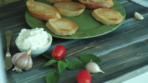 Close-up shot of a womans hand is prepared from bread cheese and vegetables for an Italian bruschetta. — Stock Video