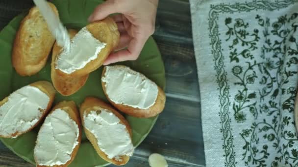 El primer plano de la mano femenina es preparado del queso de pan y hortalizas para la bruschetta italiana . — Vídeos de Stock