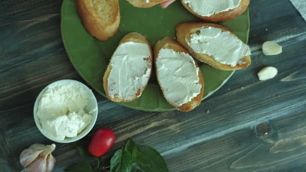 Imaginea de aproape a unei mâini de femeie este preparată din brânză de pâine și legume pentru o bruschetta italiană. . — Videoclip de stoc