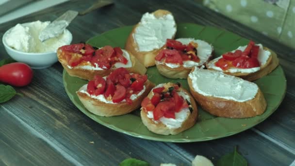 O tiro de close-up de uma mão de mulheres prepara-se de queijo de pão e verduras de uma bruschetta italiana . — Vídeo de Stock