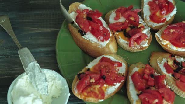 梨花の手のクローズ アップ ショットはイタリアのブルスケッタのパン チーズと野菜から調製しました。. — ストック動画