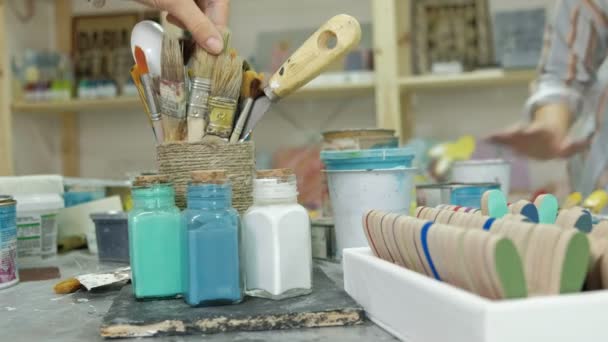 Τα χέρια του fingering το βάζο και τα μπουκάλια των χρωμάτων, επιλέγοντας το σωστό χρώμα για τα αγγεία — Αρχείο Βίντεο