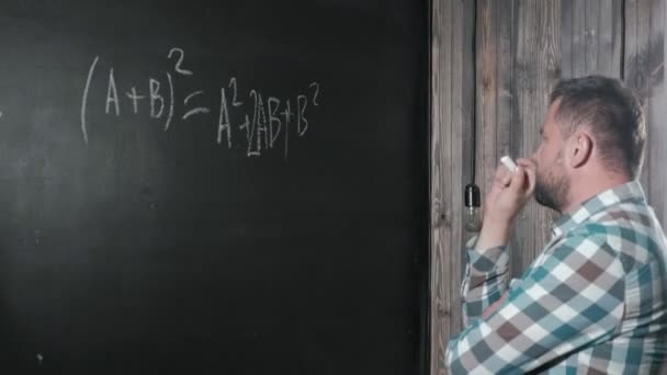 Ein brillanter Mathematiker bringt ein großes Brett mit und vervollständigt einen Aufsatz über komplizierte mathematische Formelgleichungen — Stockvideo