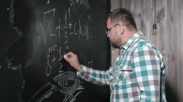 Ein brillanter Mathematiker bringt ein großes Brett mit und vervollständigt einen Aufsatz über komplizierte mathematische Formelgleichungen — Stockvideo