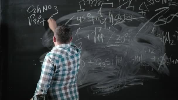 Een briljante volwassen wiskundige brengt een groot bord en voltooit een essay ingewikkelde wiskundige formule vergelijking — Stockvideo