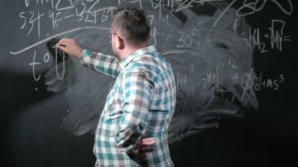 Een briljante volwassen wiskundige brengt een groot bord en voltooit een essay ingewikkelde wiskundige formule vergelijking — Stockvideo
