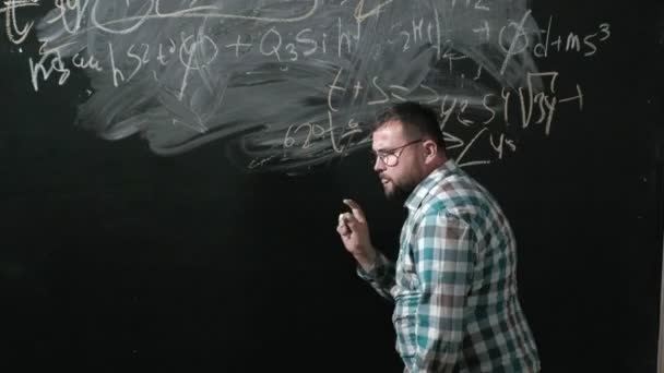En lysande mogen matematiker tar en stor styrelse och slutför en uppsats komplicerade matematiska formeln formel — Stockvideo
