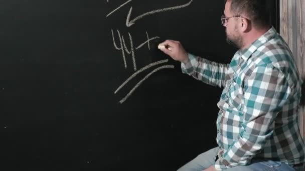 Ein brillanter Mathematiker bringt ein großes Brett mit und vervollständigt einen Aufsatz über komplizierte mathematische Formelgleichungen — Stockvideo