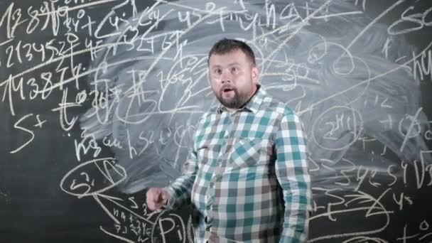 Seorang matematikawan dewasa yang brilian membawa papan besar dan menyelesaikan persamaan rumus matematika rumit — Stok Video