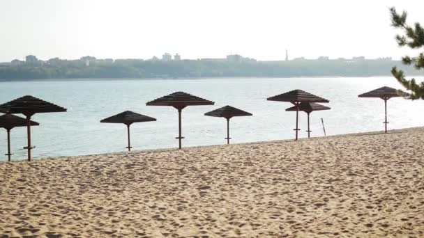 Винтажный летний пляж с деревянными зонтиками — стоковое видео