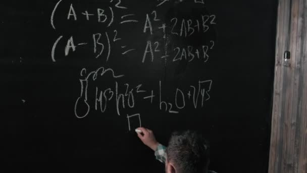 A brilliant mature mathematician brings a big board and completes an essay Complicated mathematical formula equation — Stock Video