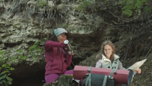 Женщина-туристка изучает бумажную карту маршрута в лесу — стоковое видео