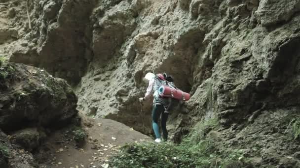 Vandring personer - turister par vid solnedgången i bergen. Resenären kvinna vandra till fots med ryggsäckar i ett spår vid solnedgången i bergen — Stockvideo