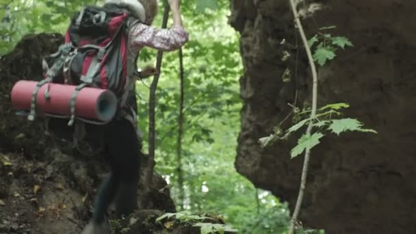 Пешие туристы - пара туристов на закате в горах. Путешествующая женщина ходит пешком с рюкзаками в тропе на закате в горах — стоковое видео