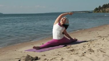 Sahilde bazı yoga yaparken eski emekli kadın