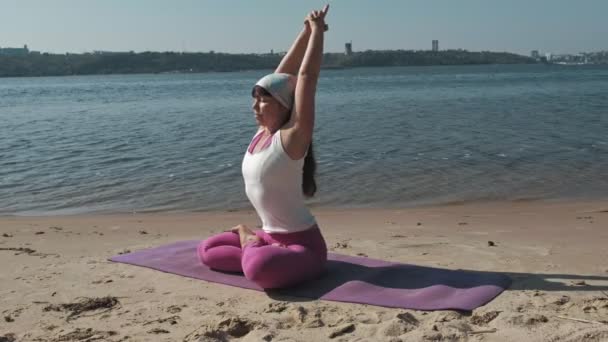 Emerytowany kobieta robi niektóre jogi na plaży — Wideo stockowe