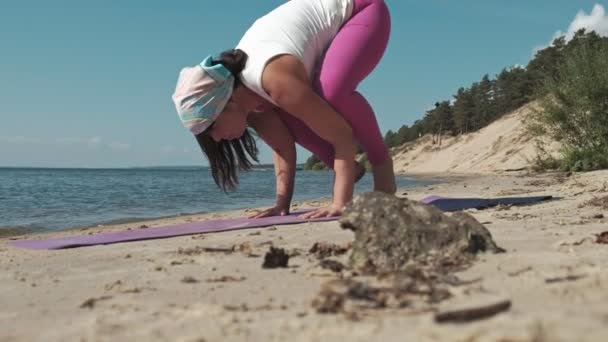 Emerytowany kobieta robi niektóre jogi na plaży — Wideo stockowe