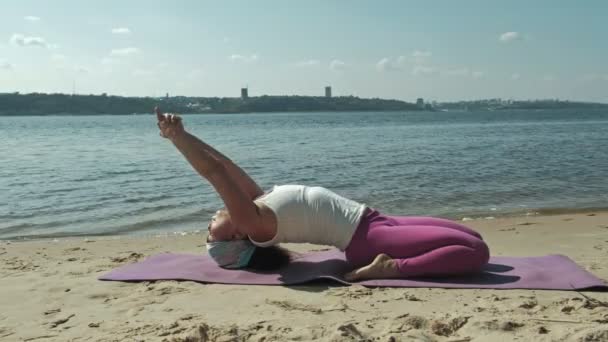 Vieja jubilada haciendo yoga en la playa — Vídeo de stock