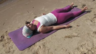 Sahilde bazı yoga yaparken eski emekli kadın