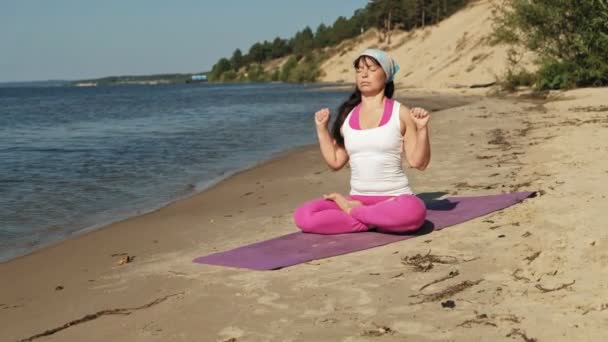 Yaşlı kadın plaj süper ağır çekim üzerinde bazı yoga yaparken emekli — Stok video