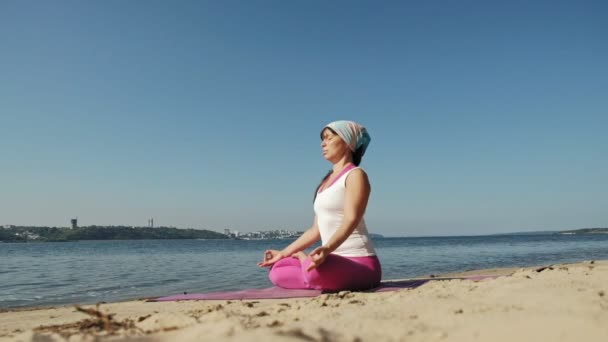 Velha mulher aposentada fazendo um pouco de ioga na praia super câmera lenta — Vídeo de Stock