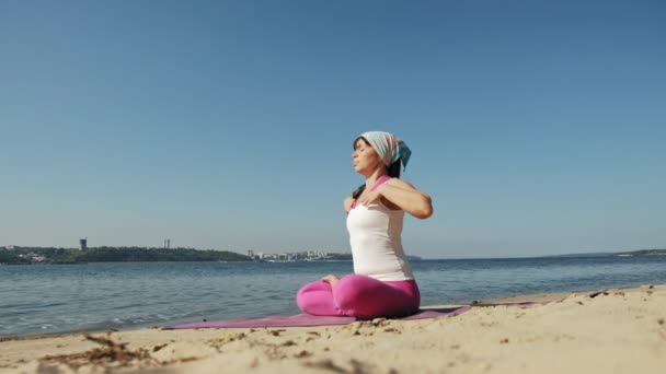 Gammal pensionerad kvinna göra några yoga på stranden super slow motion — Stockvideo
