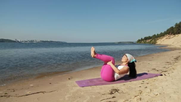 Стара жінка на пенсії робить йогу на пляжі супер повільний рух — стокове відео