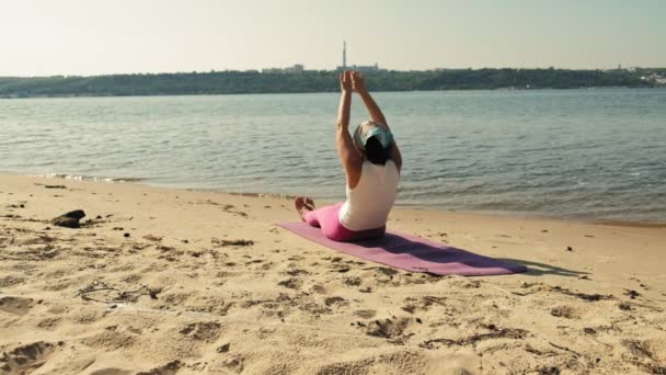 Yaşlı kadın plaj süper ağır çekim üzerinde bazı yoga yaparken emekli — Stok video