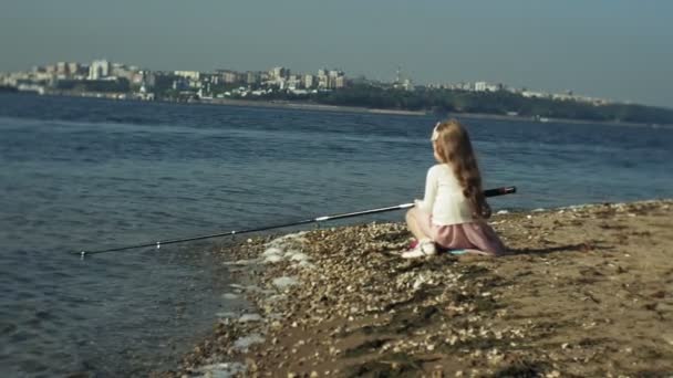 Söt liten flicka spelar med ett fiskespö på en fiskebåt nära floden — Stockvideo